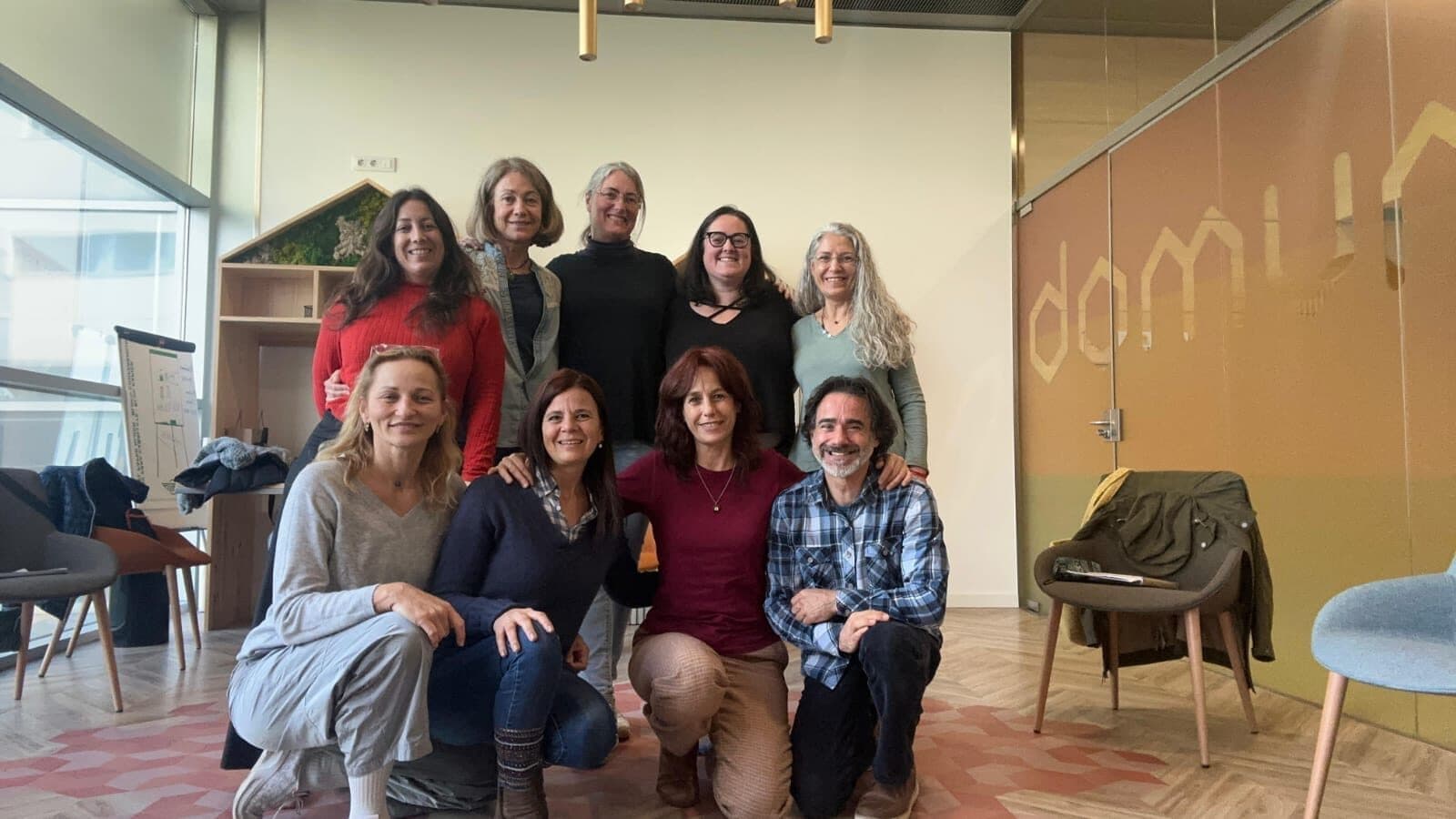Un grupo de voluntarias y voluntarios de la asociación posa sonriendo en una sala